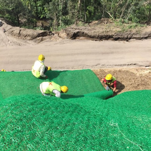 Workers are laying 3D geomat on the slope.