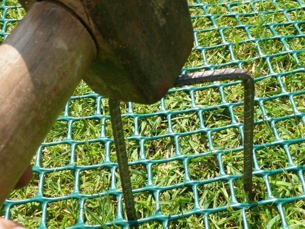 Fix the lawn reinforcement net with U staples.
