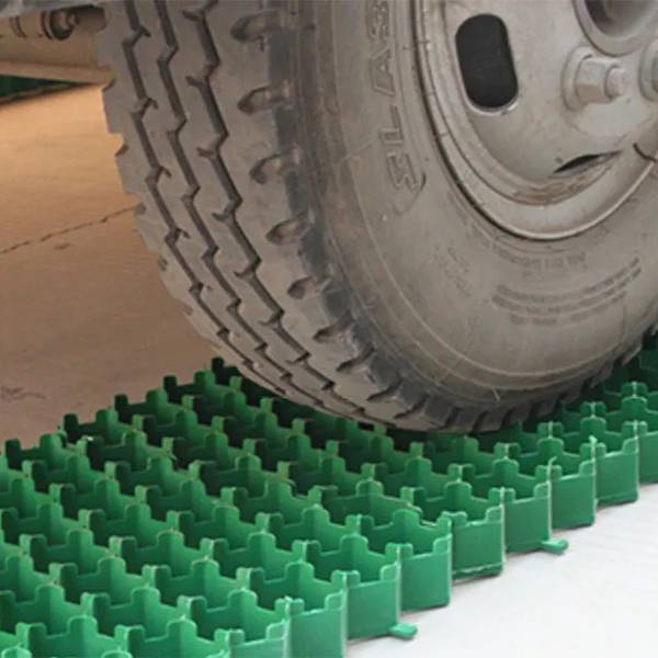 The vehicle wheel is driving on the plastic grass paver.