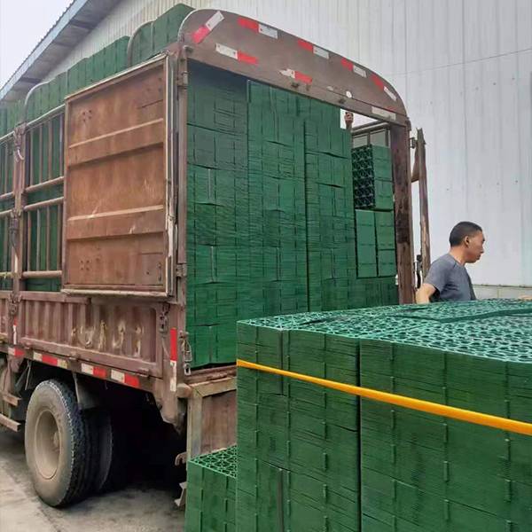 The worker is loading the plastic grass paver products for shipment.