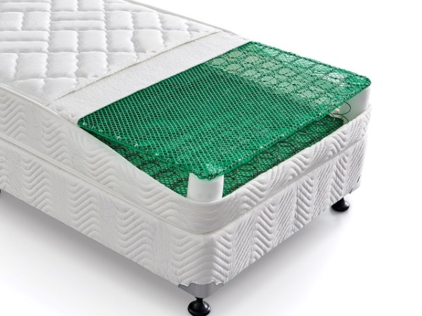 A white mattress with green plastic mattress netting