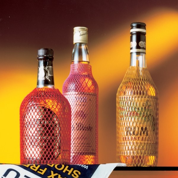 Wine bottles are covered with plastic protective sleeves.