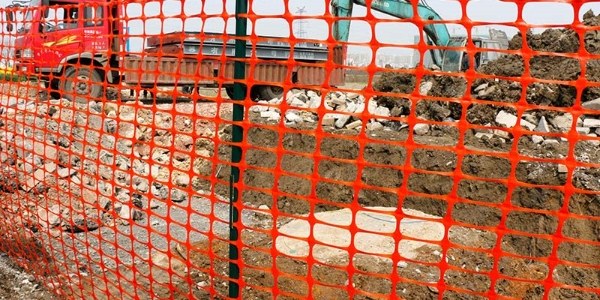 Safety barrier mesh is installed along the construction site.
