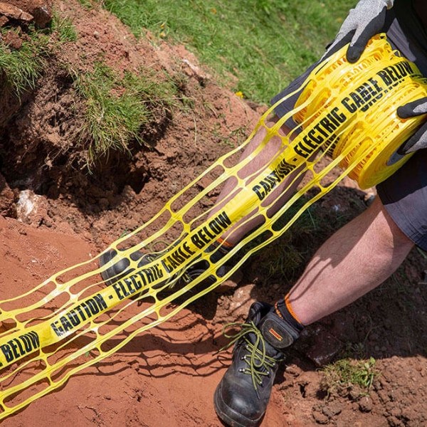 The worker is laying the underground warning mesh.